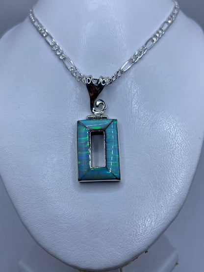 Detalle del ópalo de fuego engastado a mano en plata .950, mostrando reflejos azul cielo