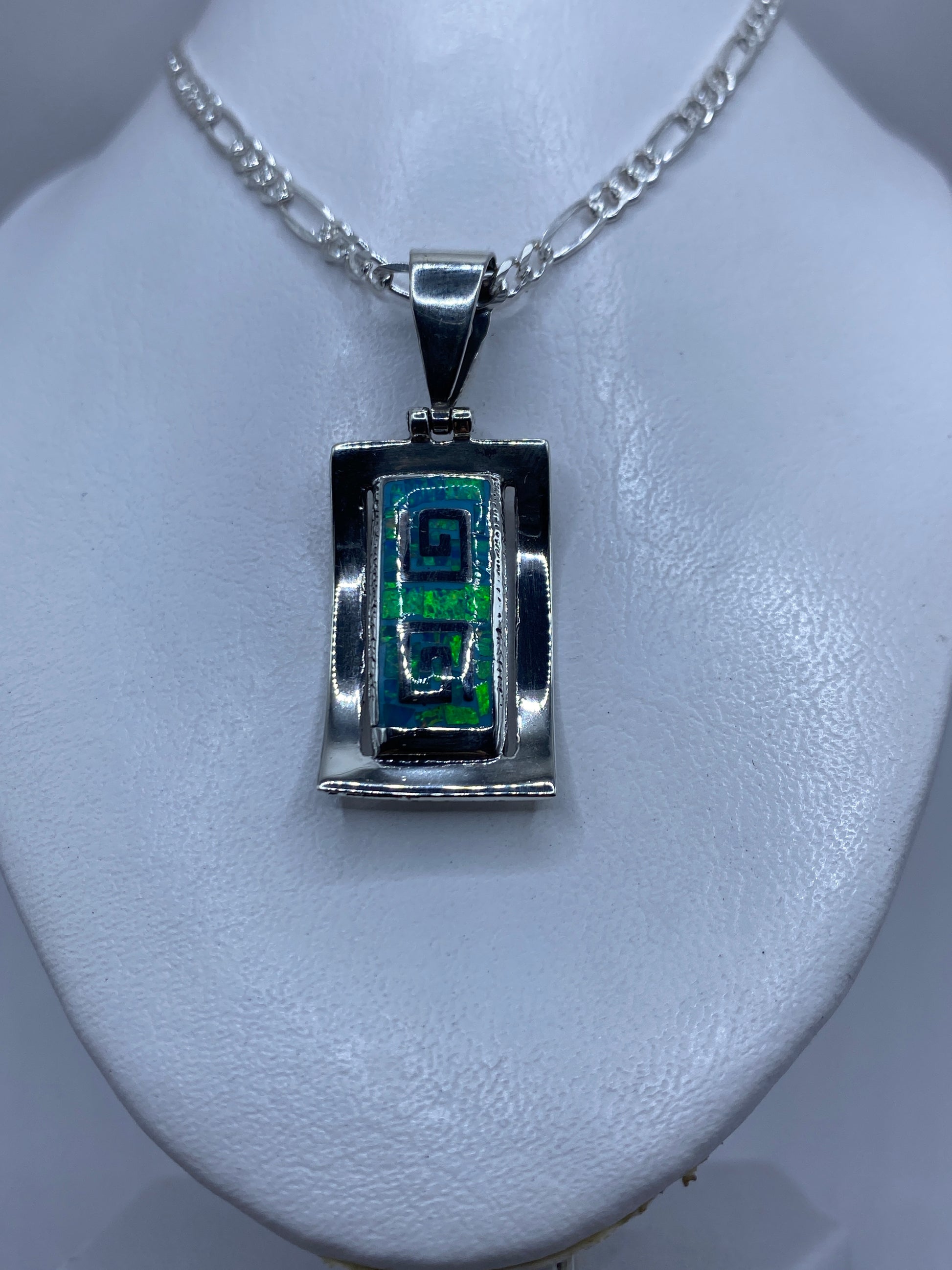 Detalle lateral del dije de plata sólida con el ópalo de fuego brillando
