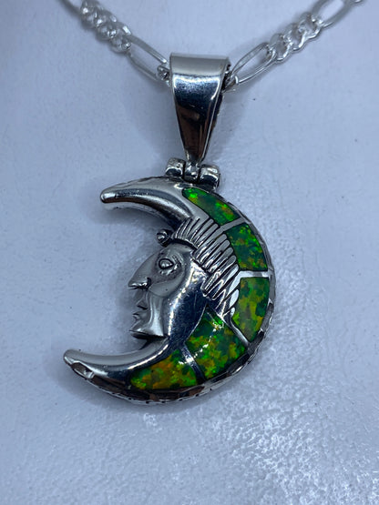 Dije de plata .950 con diseño lunar prehispánico y ópalo de fuego verde limón, visto de frente