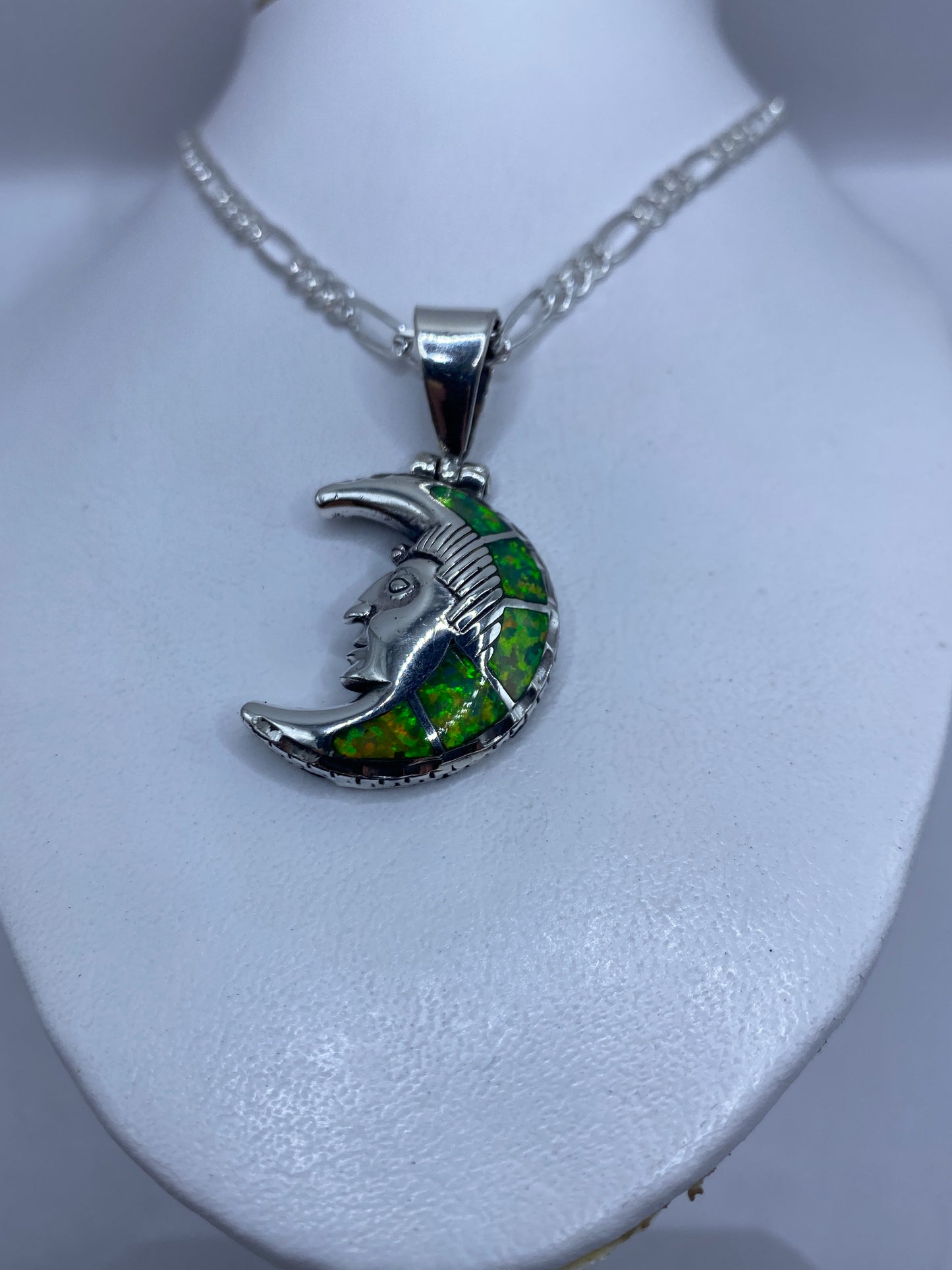 Detalle del rostro lunar y la incrustación de ópalo de fuego en tonos verde y oro