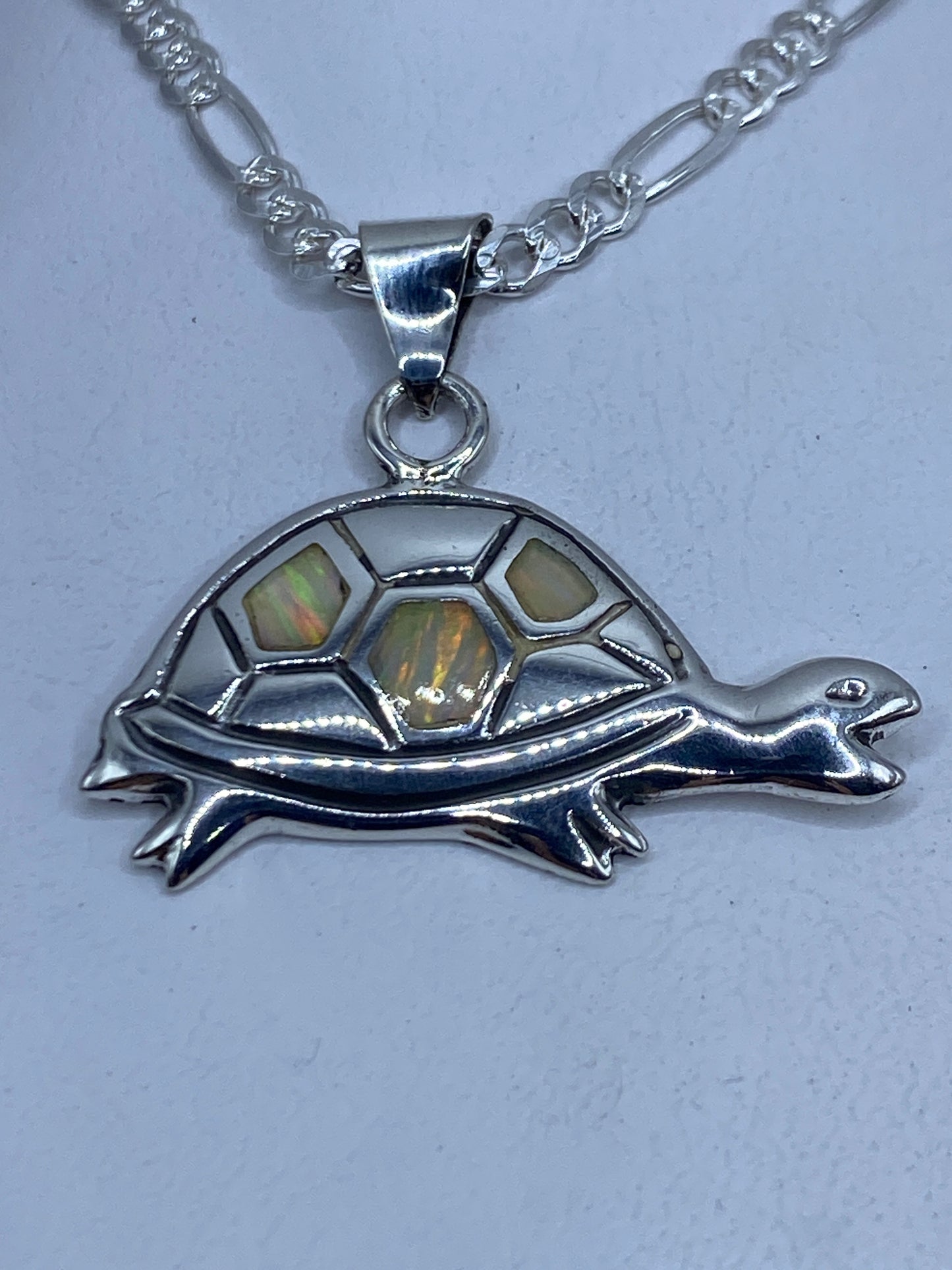 Dije de tortuga en plata .925 con ópalo de fuego multicolor colgando de cadena de plata