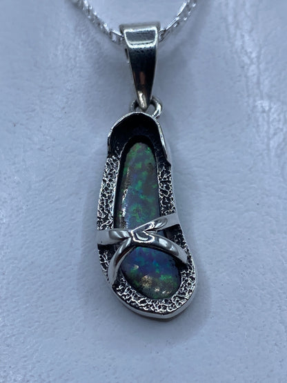 Dije de ópalo de fuego azul cielo engastado en plata .950, colgado en cadena de plata
