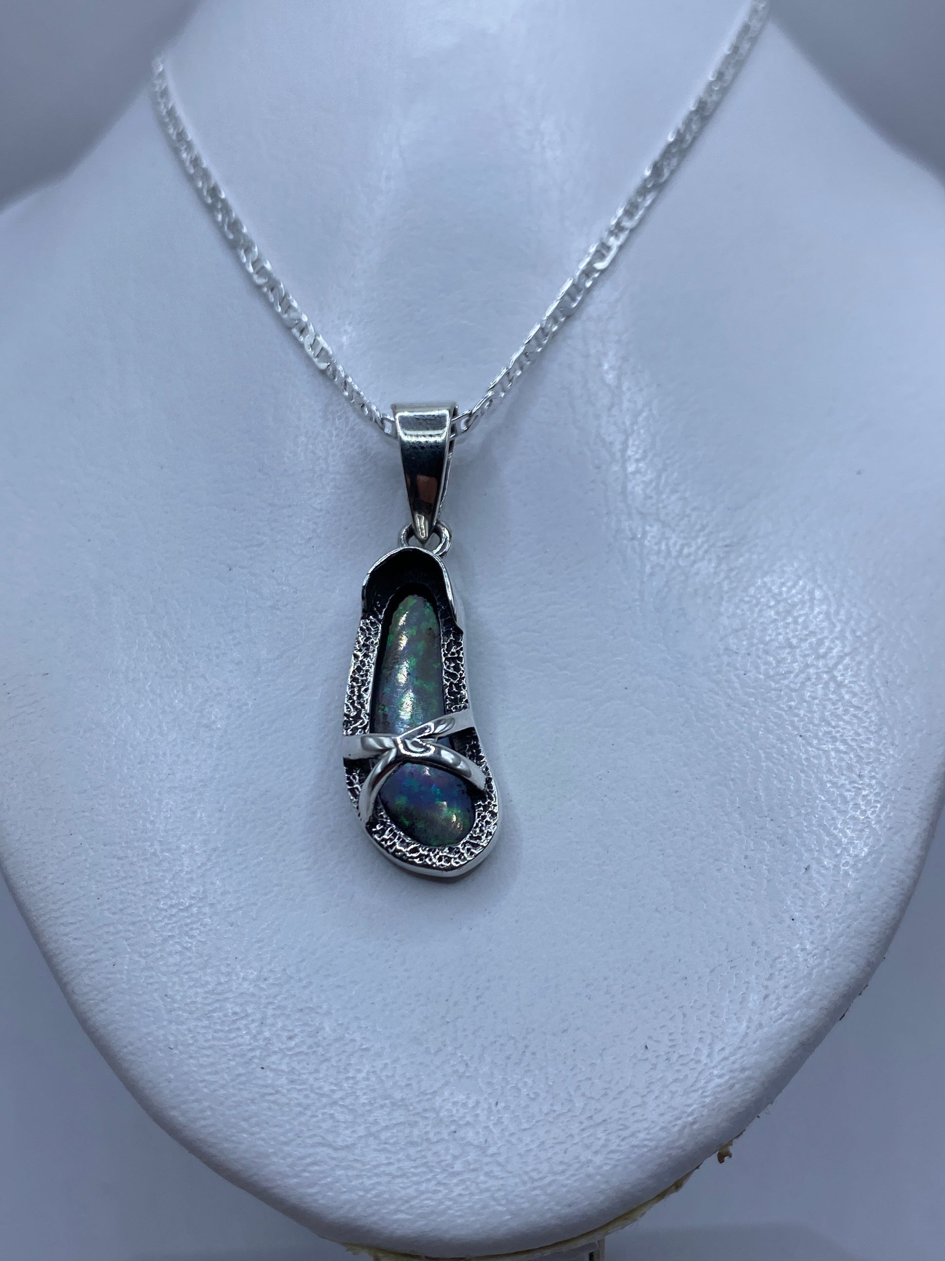 Detalle del ópalo de fuego con tonos azul y verde en engaste de plata manual