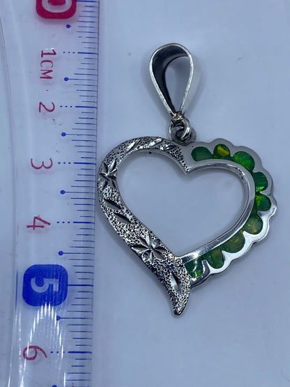 Dije corazón de 5.5 cm junto a regla mostrando el tamaño real comparado con centímetros
