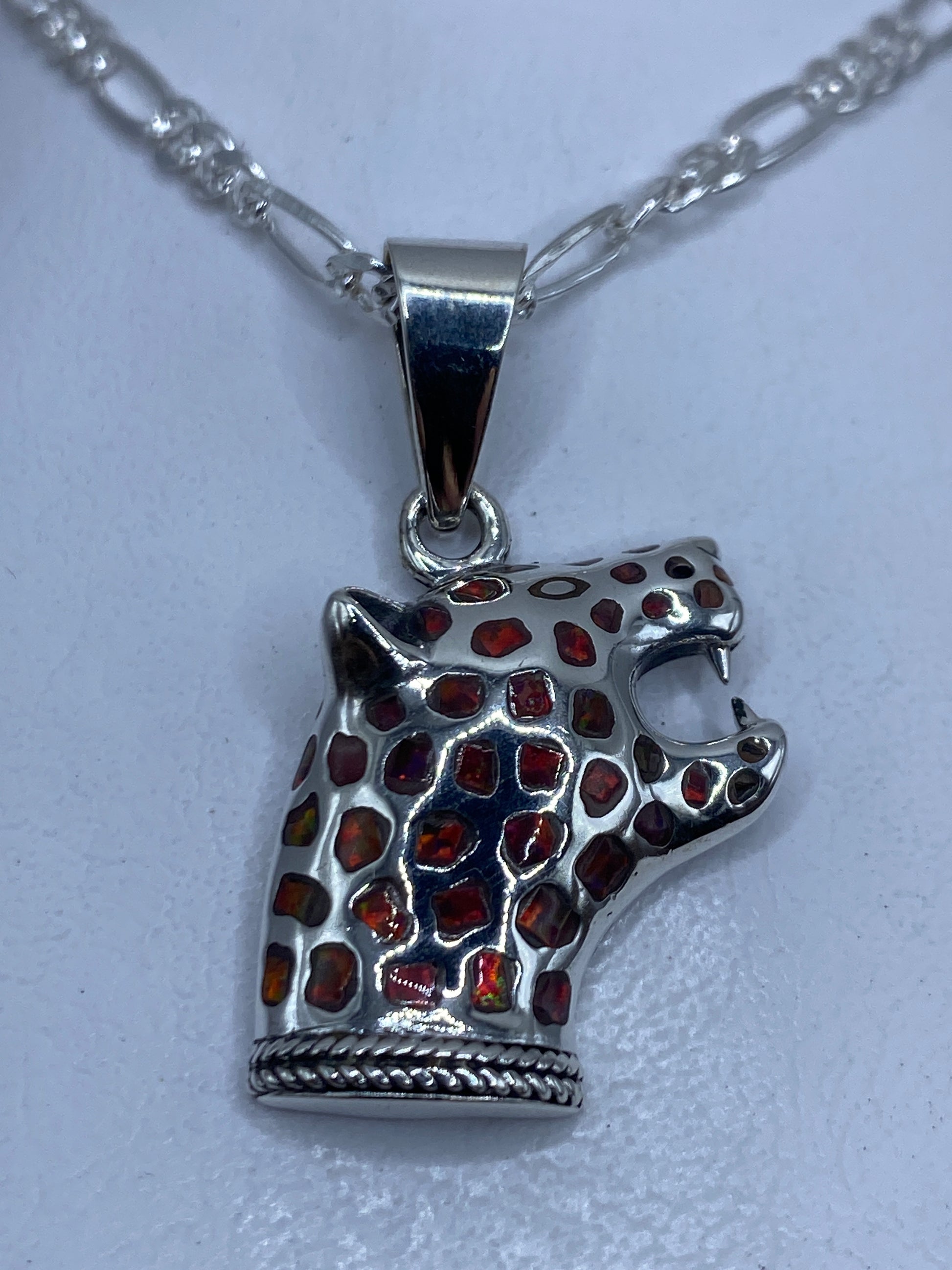 Dije jaguar en plata .950 con ópalo de fuego multicolor, colgando de cadena de plata