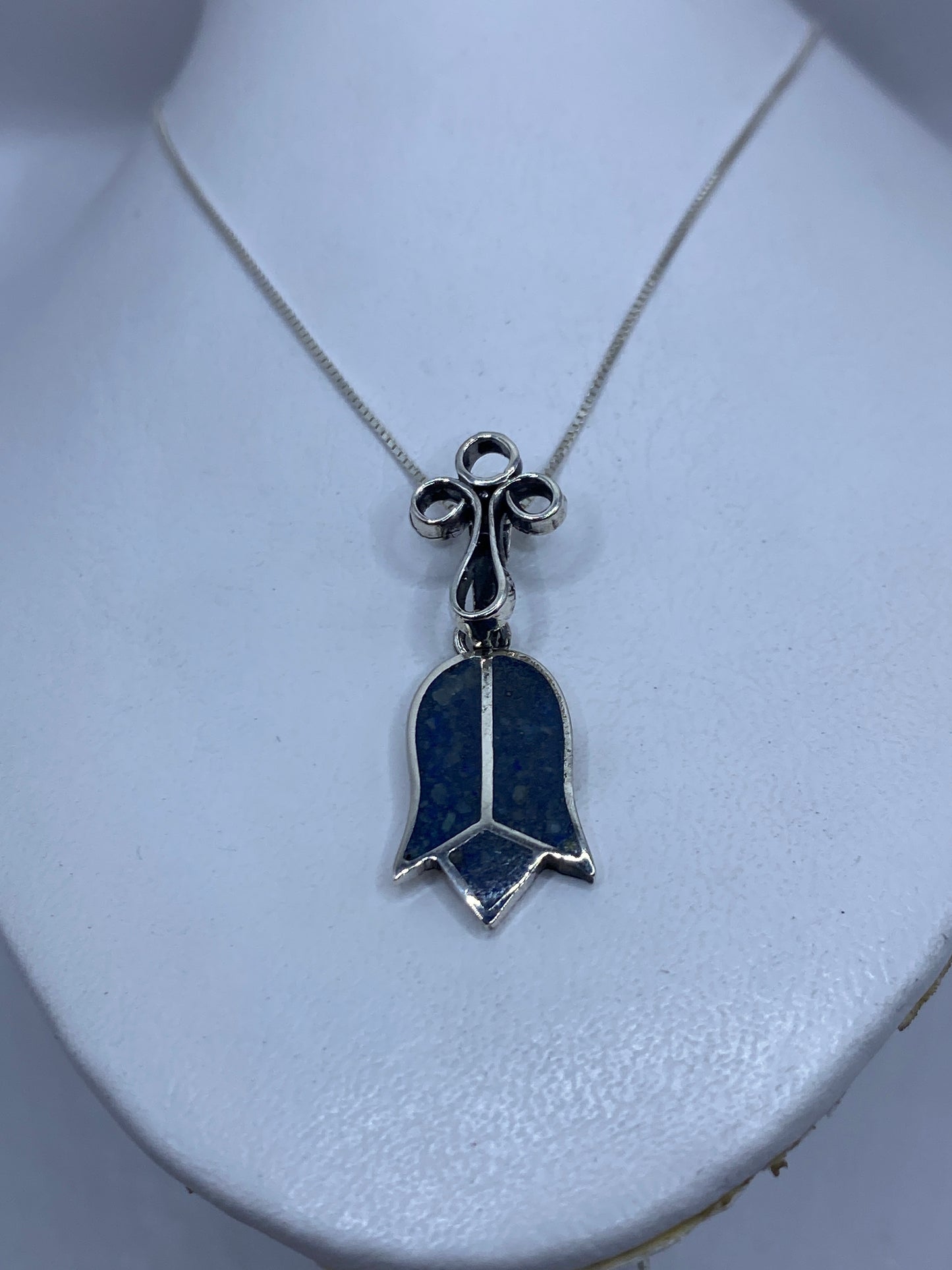 Detalle frontal de la campana con piedra azul y tres aros decorativos en plata