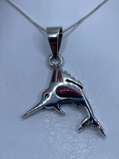 Dije de tiburón en plata .950 con ópalo de fuego multicolor, visto de frente sobre fondo blanco
