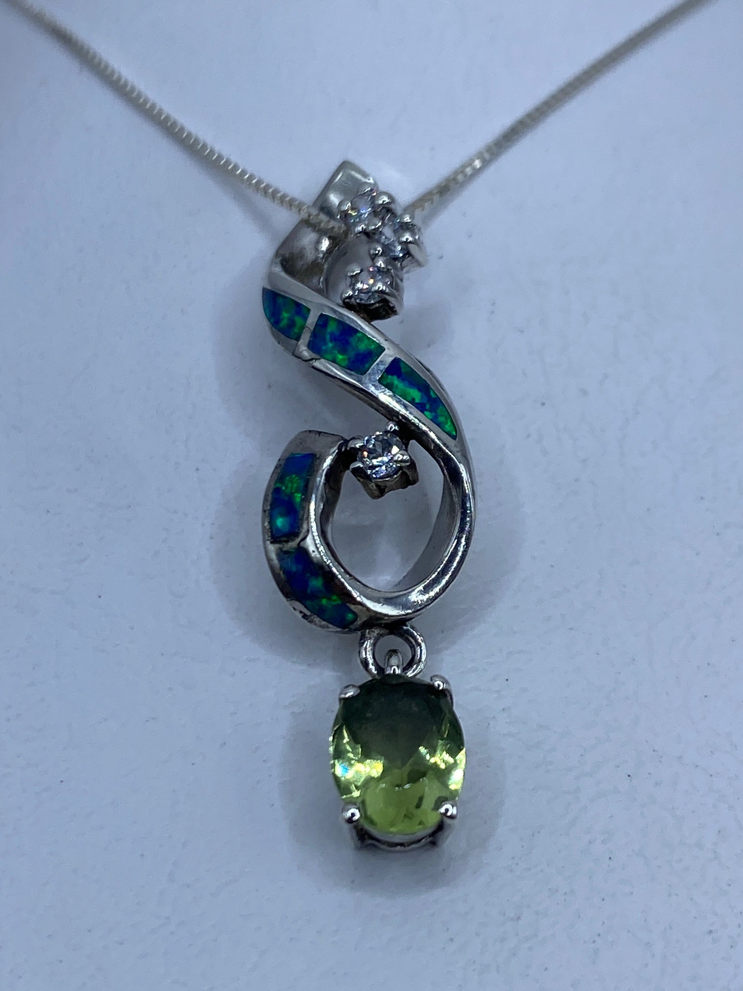 Dije de plata .925 con ópalo de fuego azul iridiscente, colgado de una cadena plateada