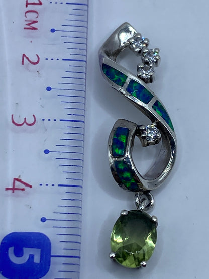 Dije de 5.5 cm de largo junto a una regla, mostrando su tamaño real en la mano