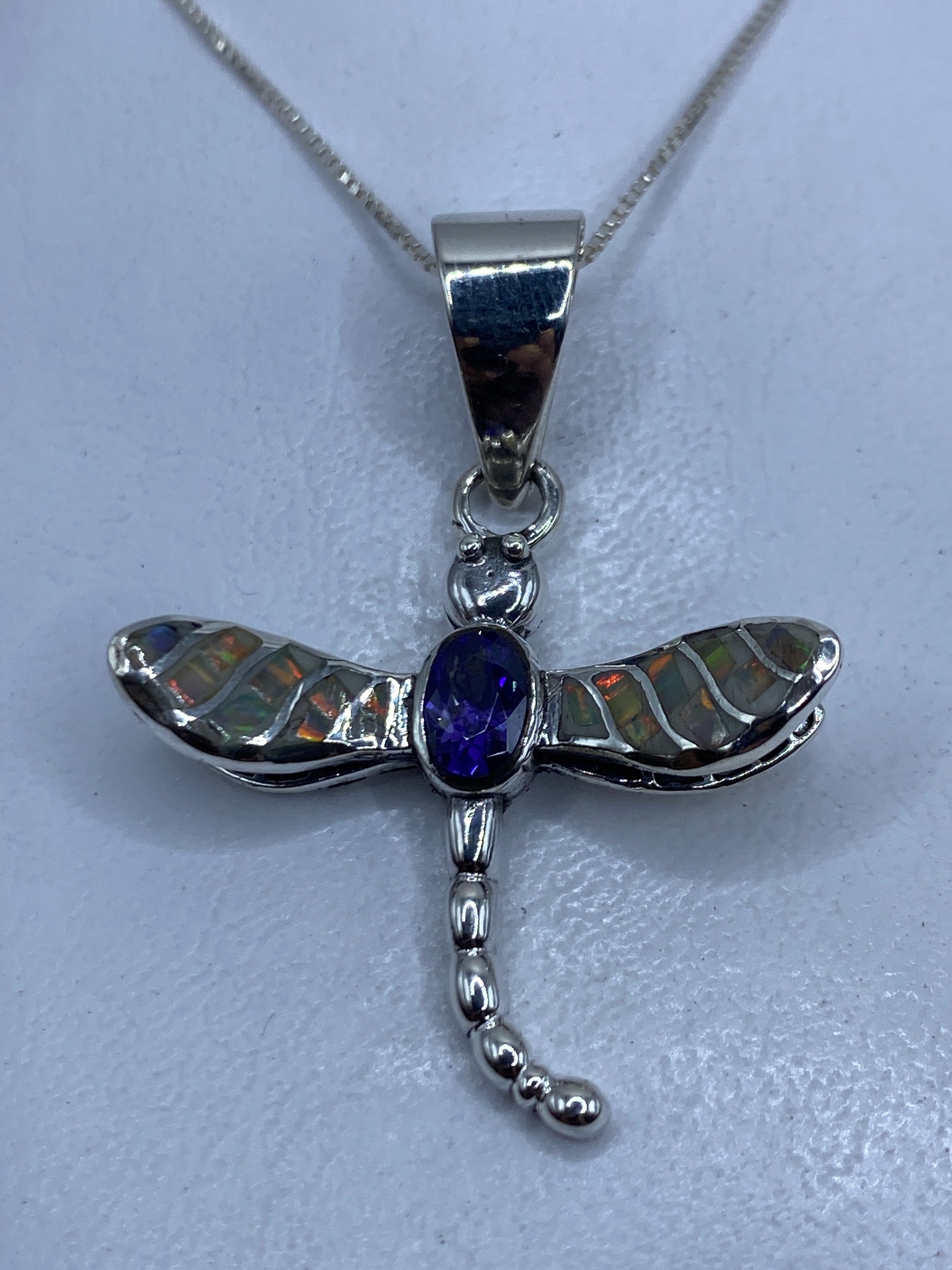 Dije libélula en plata .950 con ópalo de fuego multicolor en las alas, colgante sobre fondo blanco