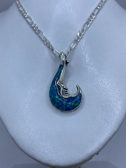 Detalle frontal del dije luna mostrando la incrustación del ópalo de fuego y los reflejos azules