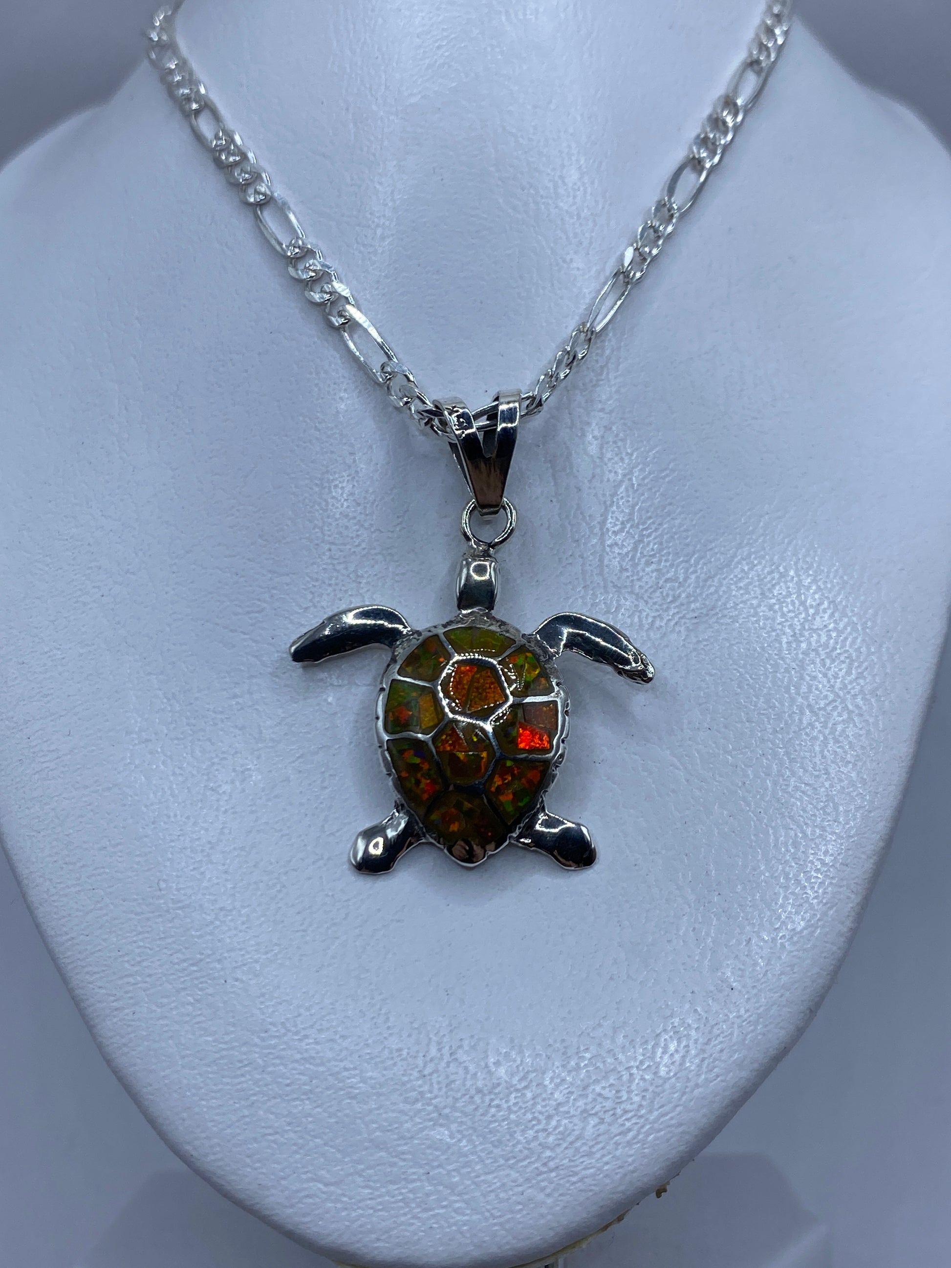 Tortuga de plata mostrando el detalle de las patas articuladas y el ópalo de fuego en tonos amarillo-naranja