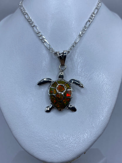 Tortuga de plata mostrando el detalle de las patas articuladas y el ópalo de fuego en tonos amarillo-naranja