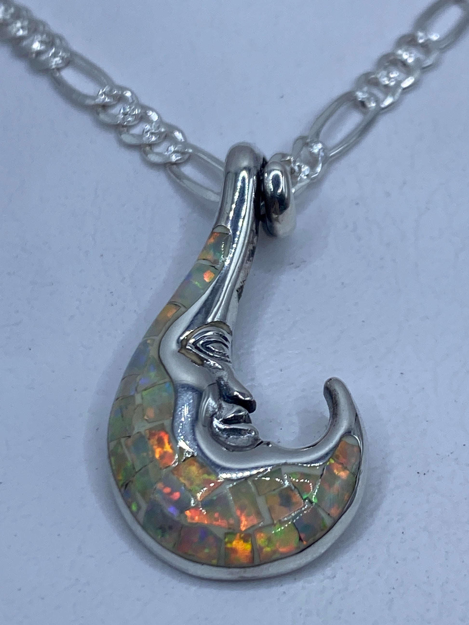 Dije de plata .950 con ópalo de fuego en forma de rostro escultural colgado en cadena figaro