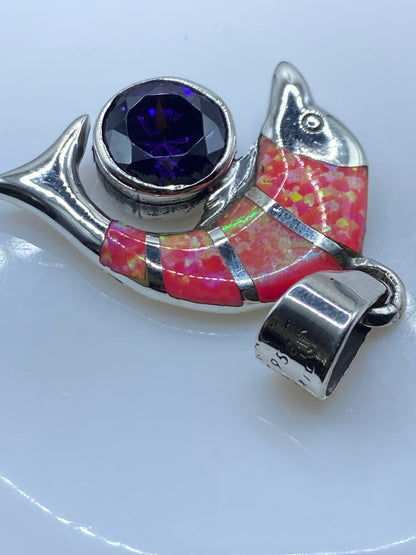 Dije pájaro de plata sobre fondo blanco mostrando el Quinto .950