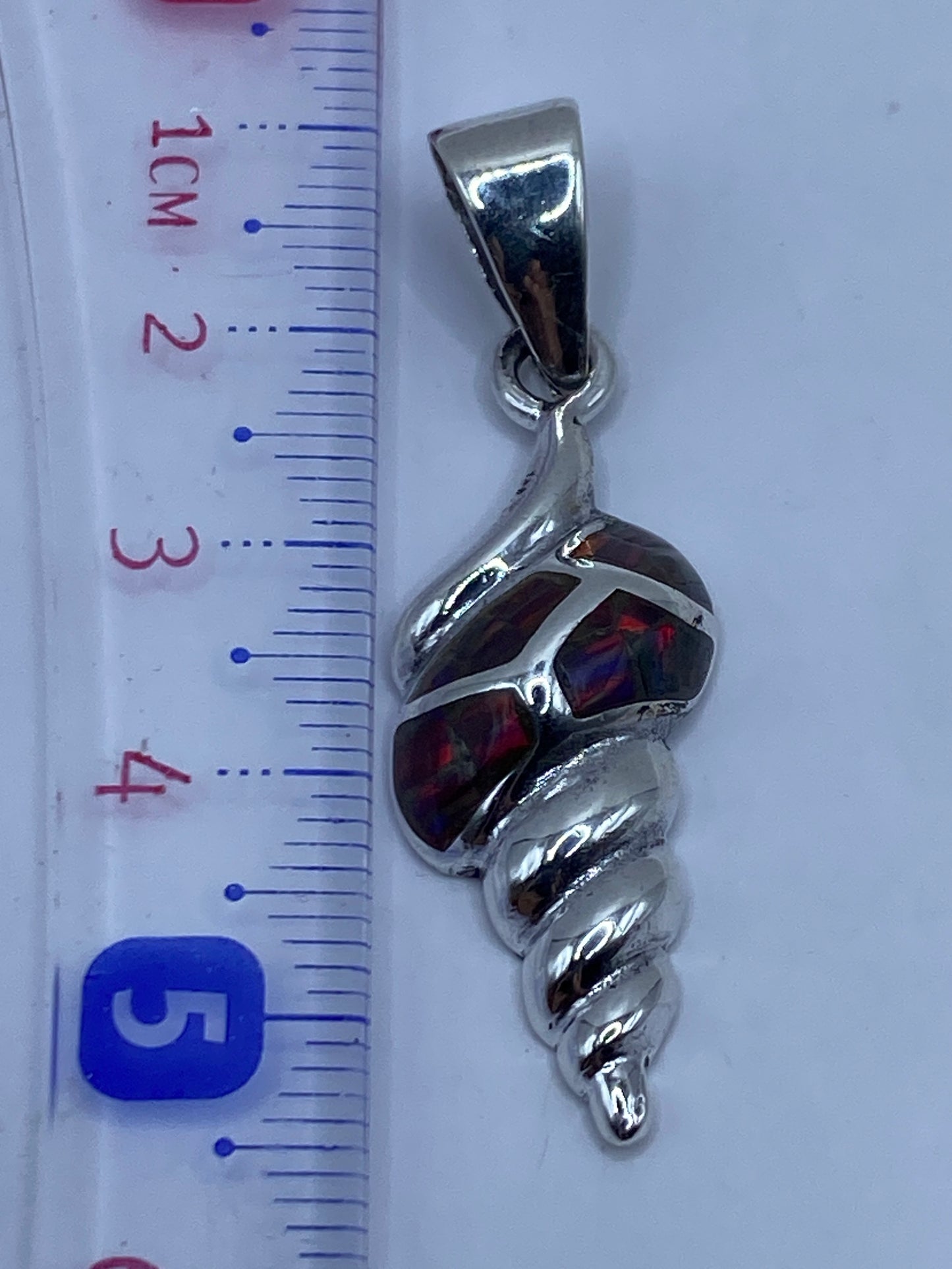 Medida del dije: 5.5 cm de largo sobre regla métrica