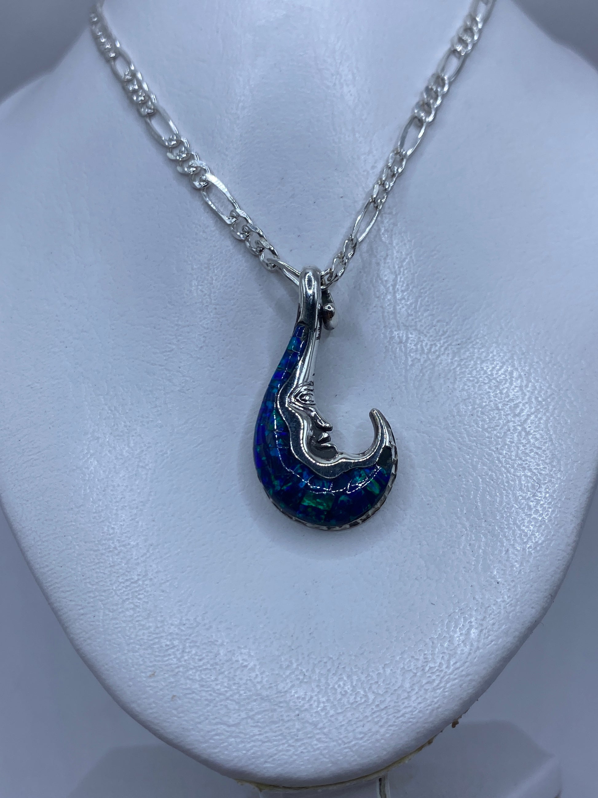 Detalle frontal del dije mostrando el ópalo de fuego con tonos azul verdoso