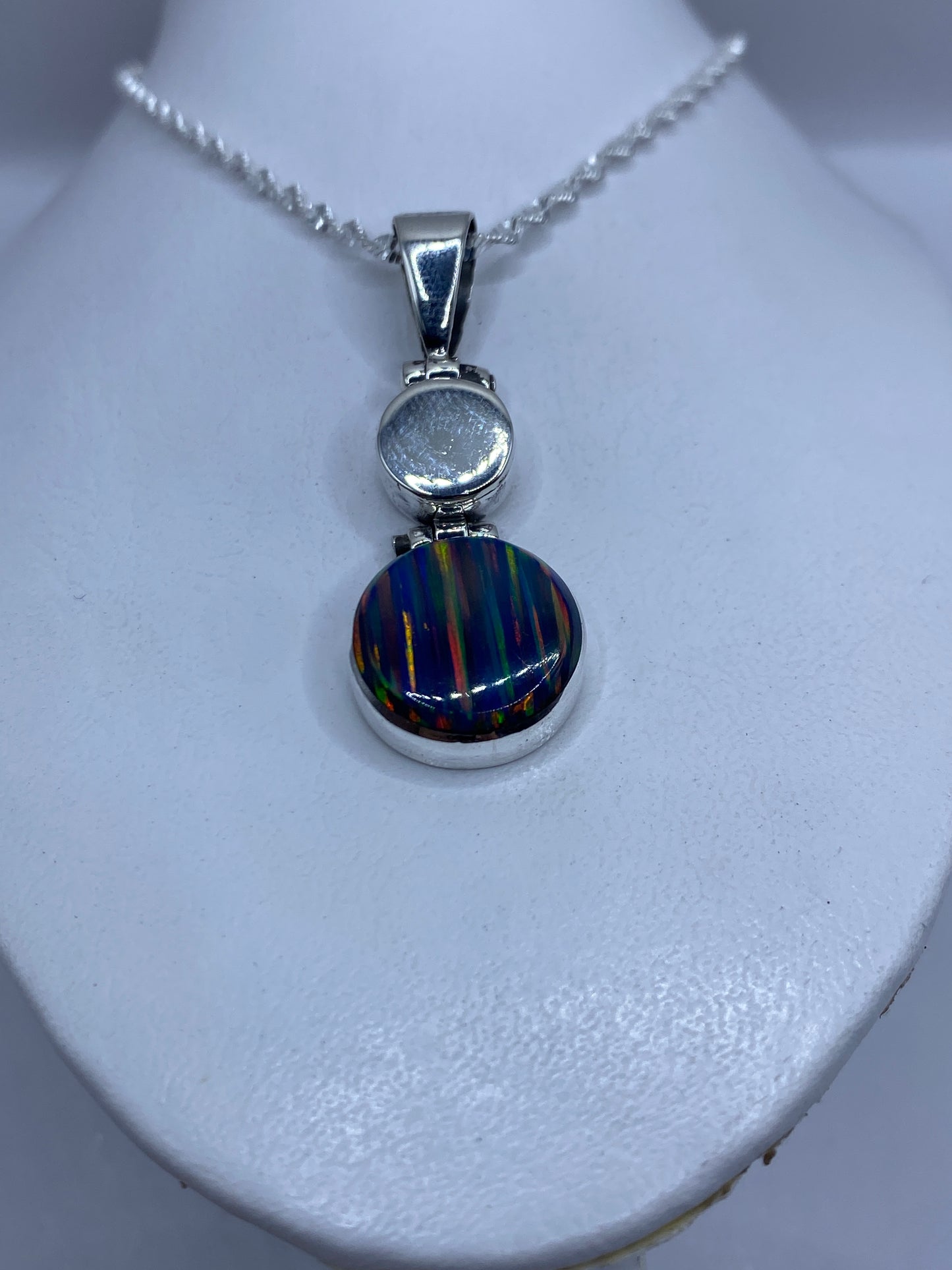 Primer plano del ópalo de fuego multicolor engastado en plata con dos esferas pulidas