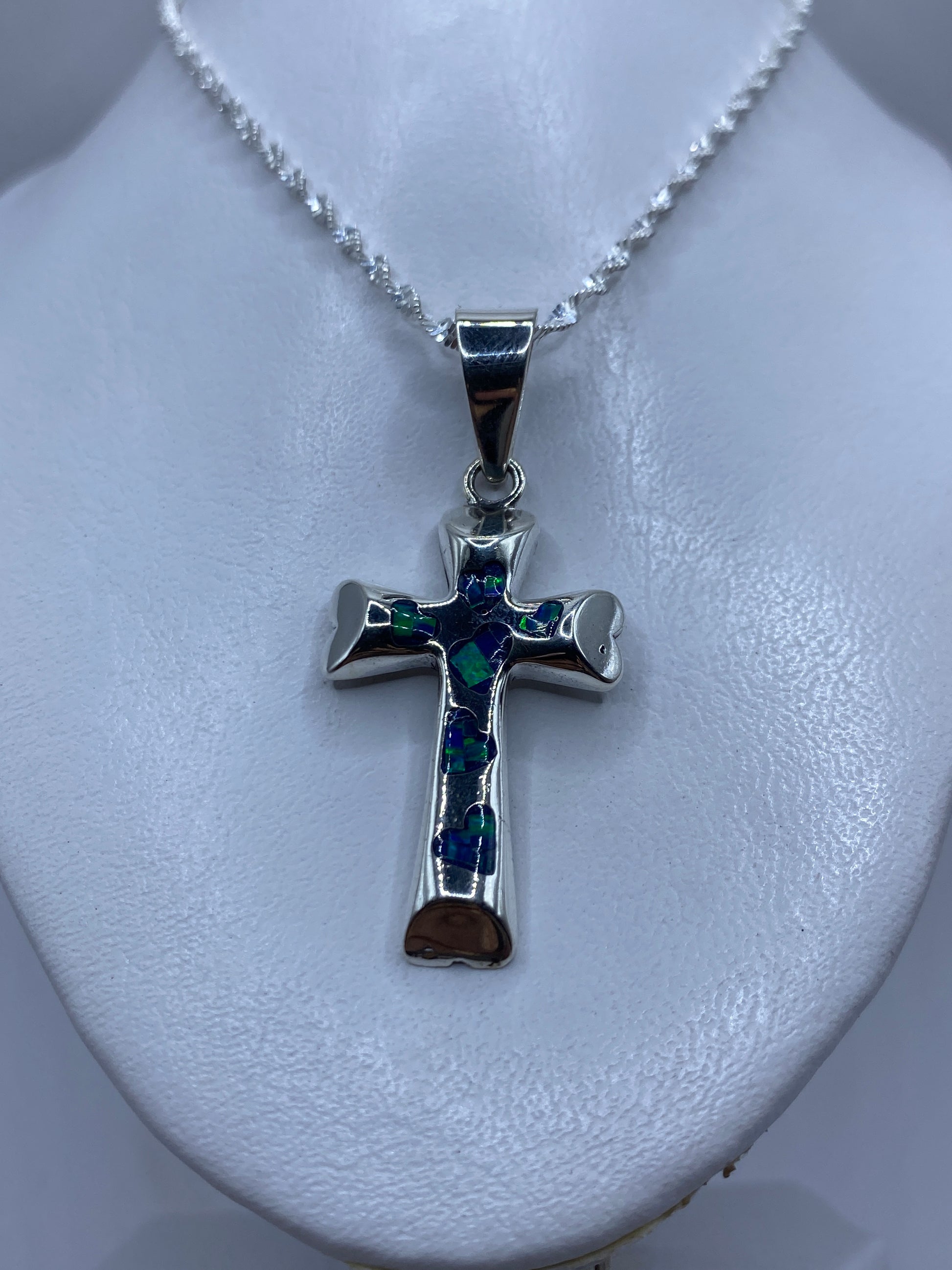 Detalle lateral de la cruz de plata con piedra incrustada a mano