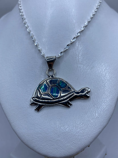 Detalle del ópalo de fuego azul engastado en el caparazón de la tortuga de plata