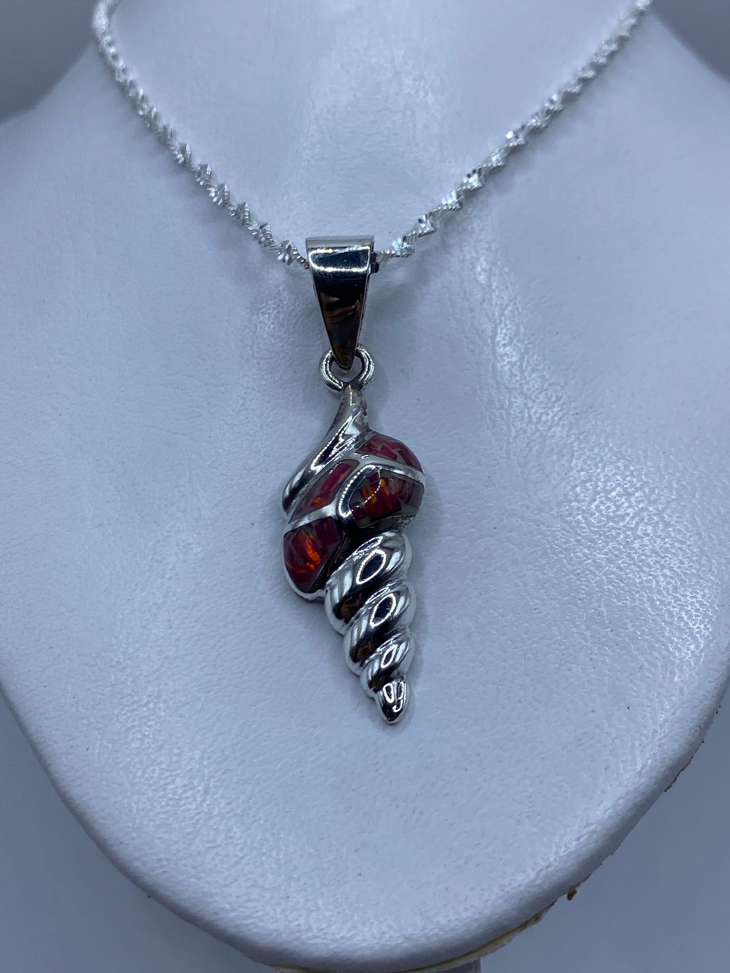 Detalle del ópalo de fuego rojo en tonos carmesí y naranja dentro del engaste de plata .950