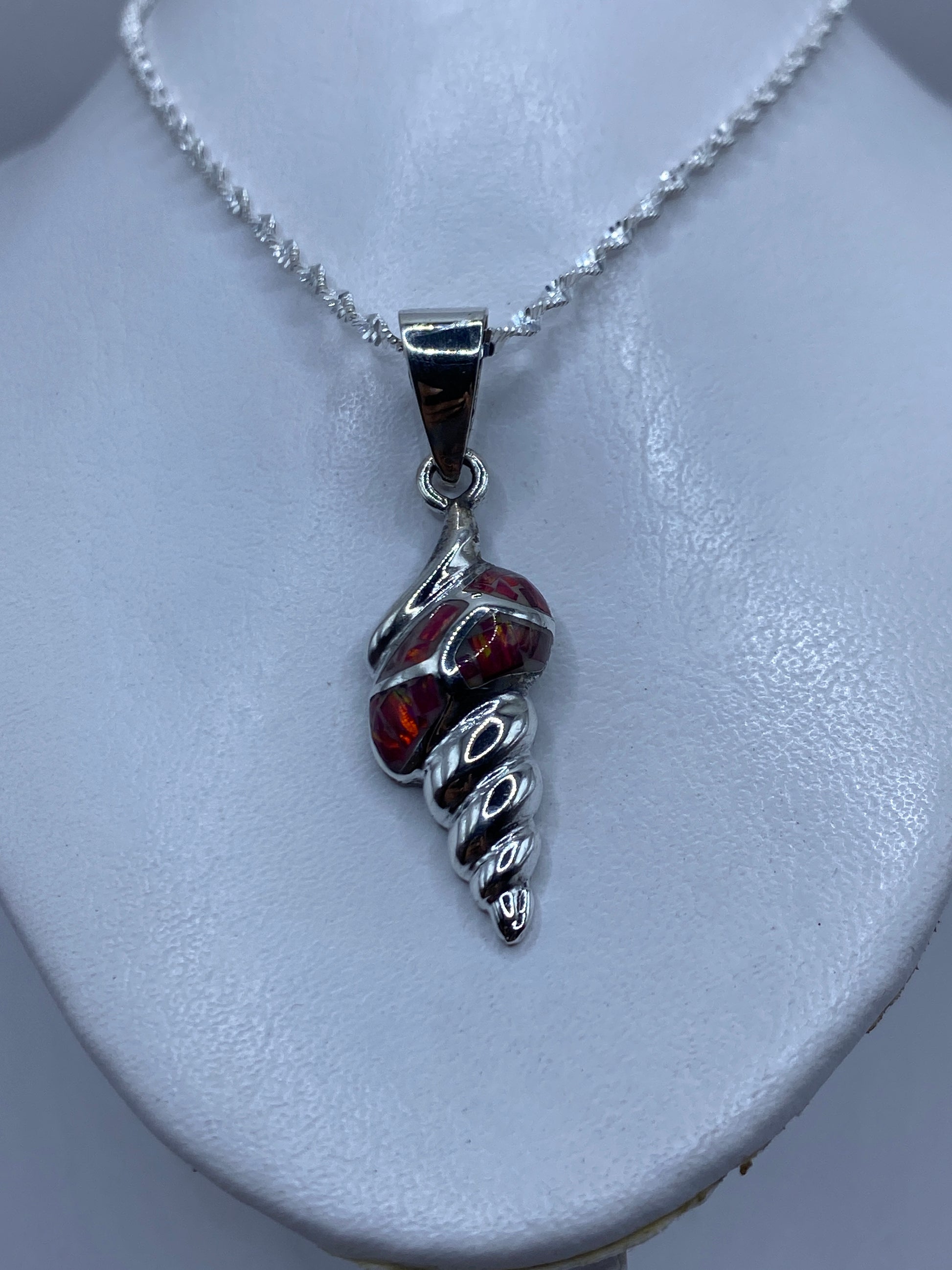 Detalle del ópalo de fuego rojo en tonos carmesí y naranja dentro del engaste de plata .950