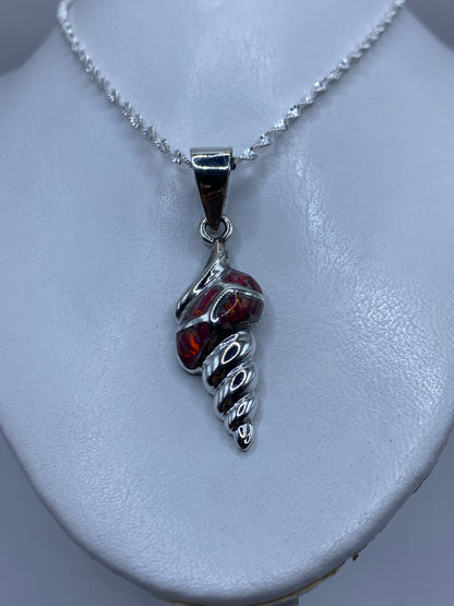 Detalle del ópalo de fuego rojo en tonos carmesí y naranja dentro del engaste de plata .950