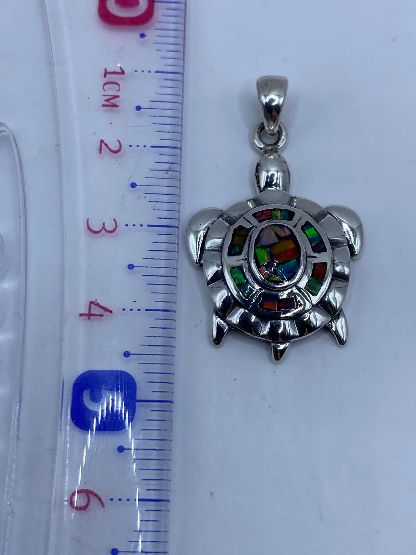 Dije tortuga sobre fondo blanco mostrando medida de 4.4 cm y el Quinto .950