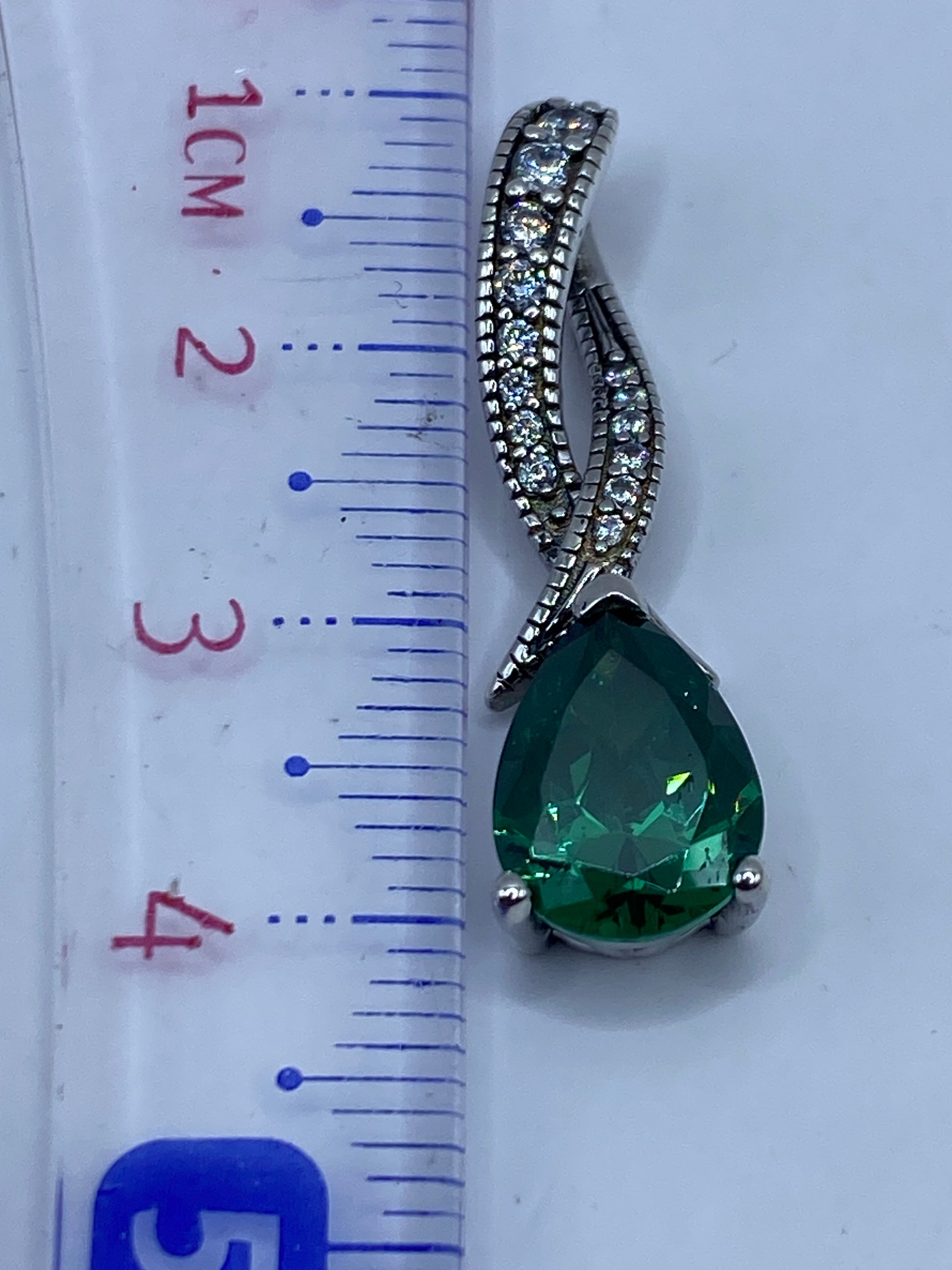 Dije de 3.8 cm junto a una regla, mostrando el tamaño real