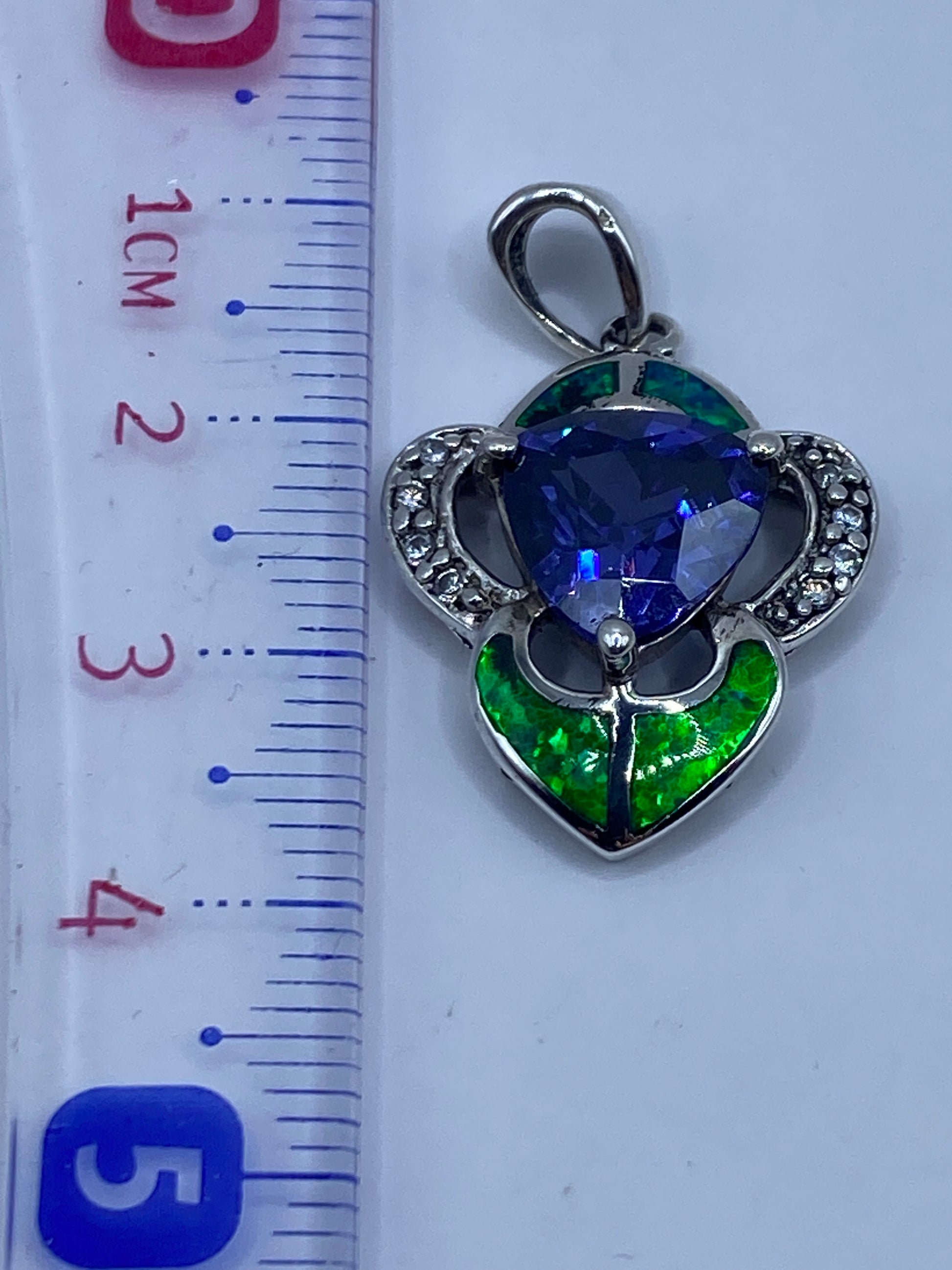 Ópalo de fuego verde en dije de plata .925 visto con regla, mostrando tamaño y Quinto