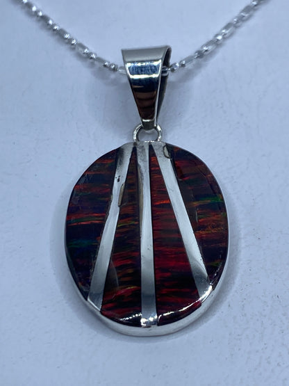 Dije de plata .950 con Ópalo de Fuego multicolor en tonos rojos, naranjas y verdes, engastado con líneas plateadas