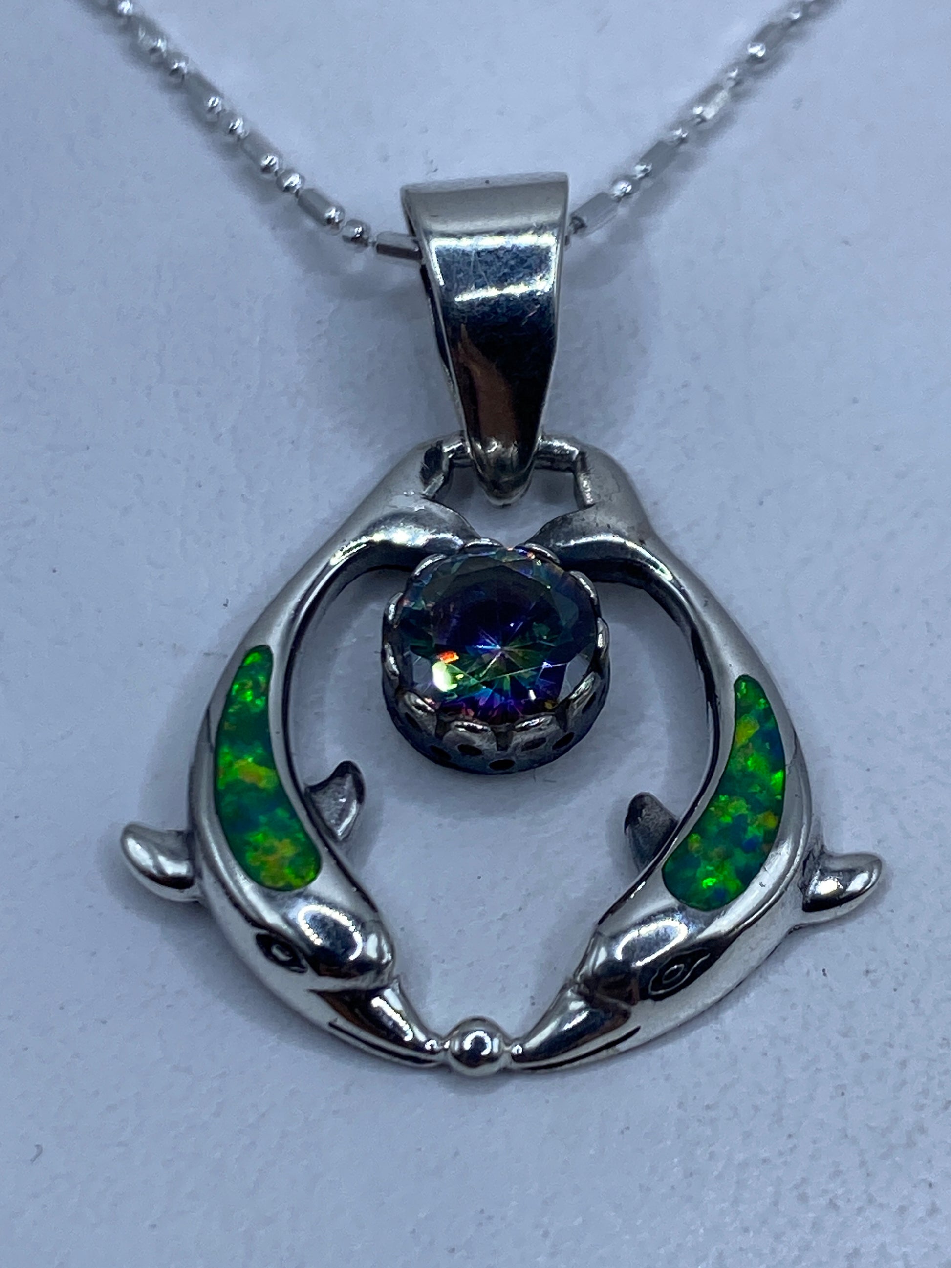 Dije de plata .950 con ópalo de fuego verde limón, dos peces de plata abrazando la piedra