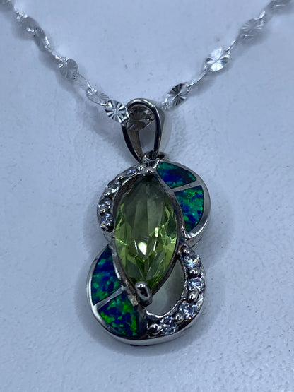 Dije de plata .925 con ópalo de fuego azul engastado a mano, colgando de cadena artesanal