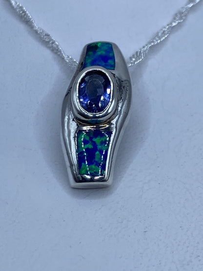 Dije de plata .925 con ópalo de fuego azul engastado, colgando de cadena plateada