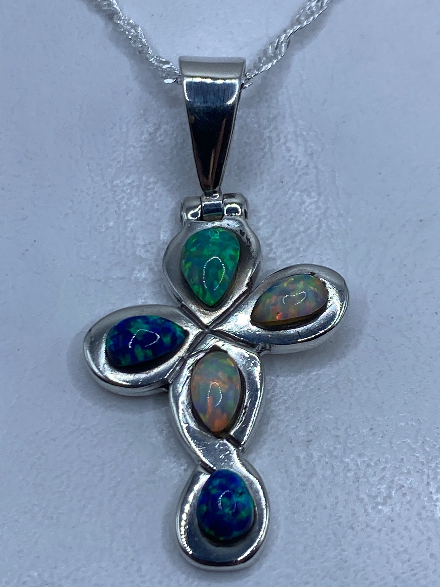 Dije cruz de plata .925 con ópalo de fuego multicolor engastado, en cadena plateada