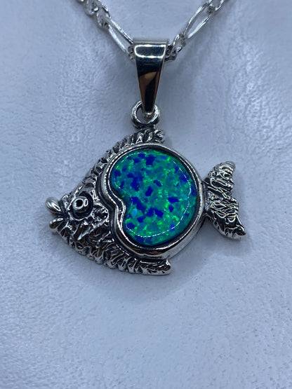 Dije pez de plata .950 con ópalo de fuego azul engastado, sobre cadena plateada