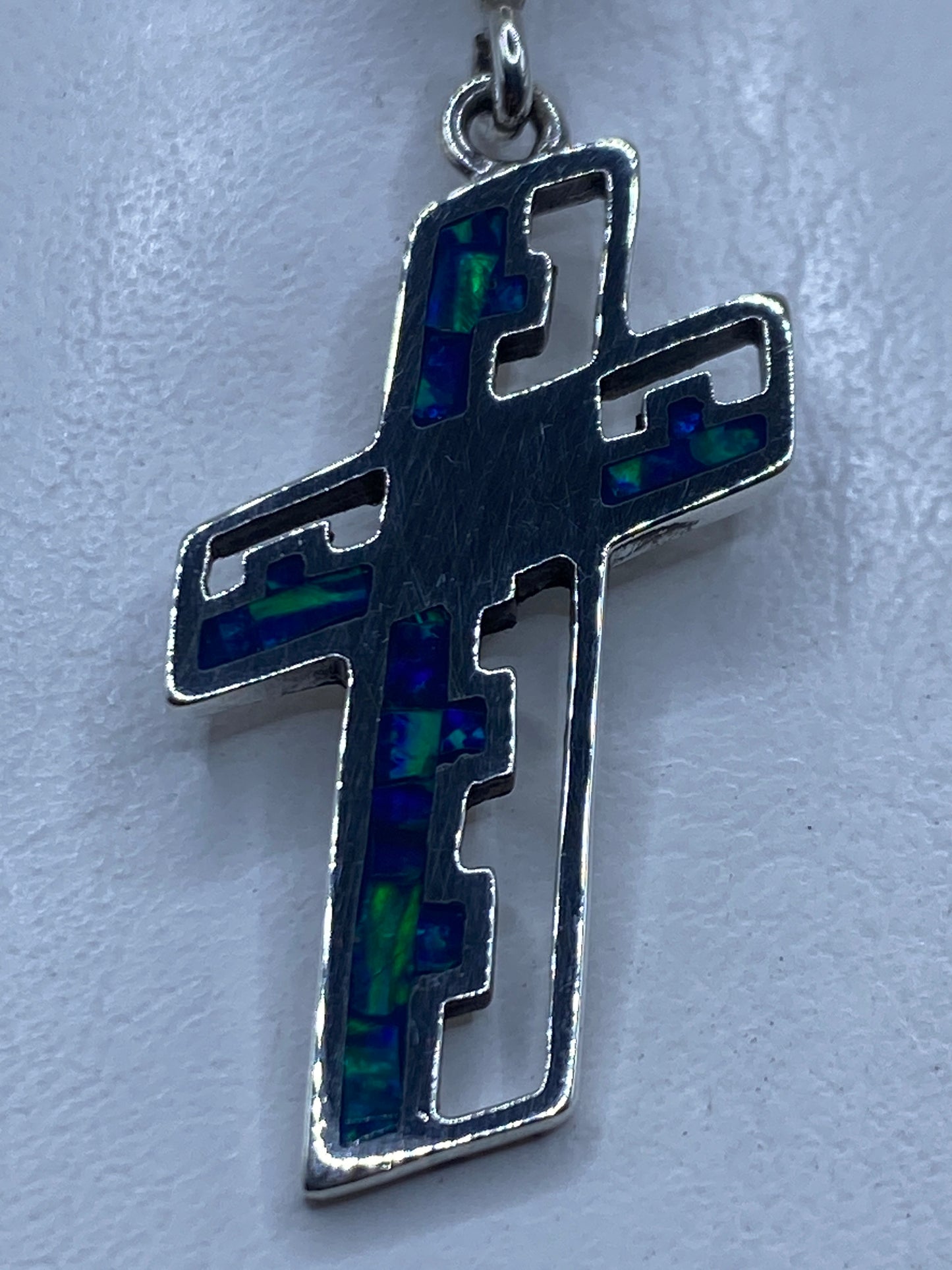 Dije cruz de plata .950 con ópalo de fuego azul, vista frontal detallada