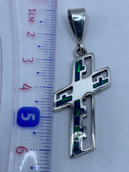 Dije cruz de 6.1 cm con Quinto .950 en reverso, sobre estuche blanco
