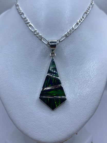 Vista frontal del dije geométrico mostrando el ópalo de fuego y las bandas de plata