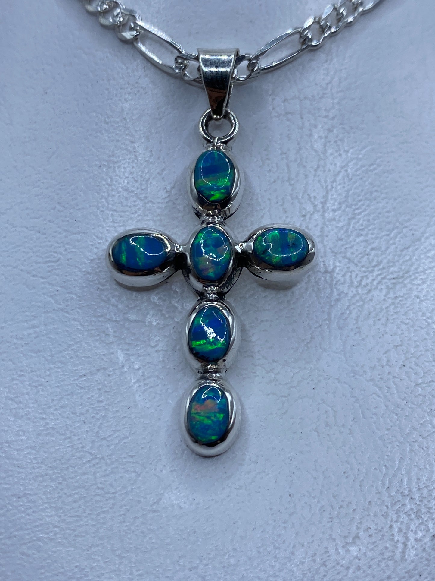 Dije cruz de plata .950 con ópalo de fuego azul cielo engastado, colgando de cadena