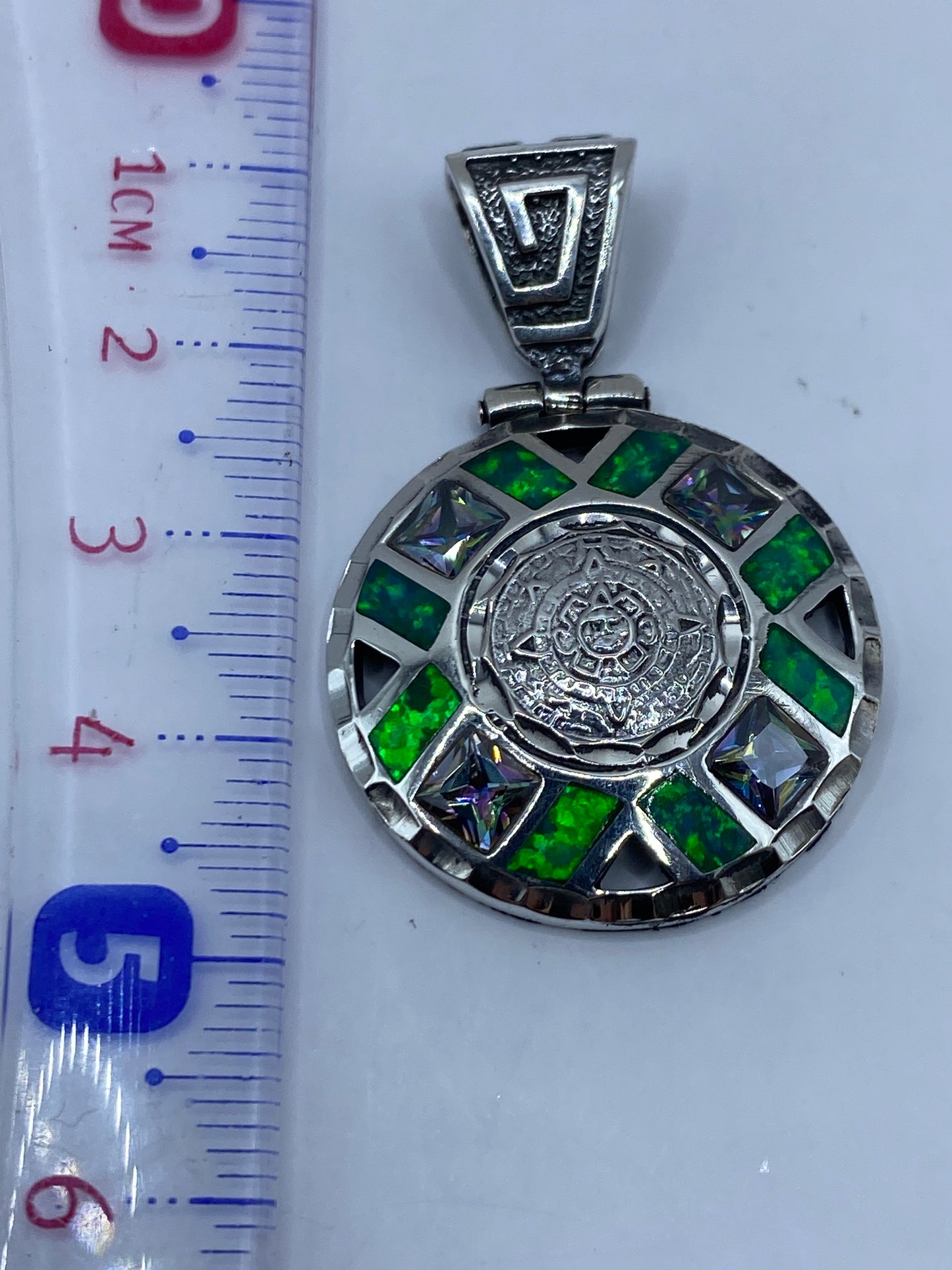 Reverso del dije mostrando la textura labrada y el Quinto de plata .950