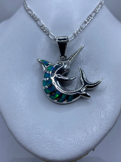 Detalle de la incrustación de ópalo de fuego azul en el cuerpo del narval de plata