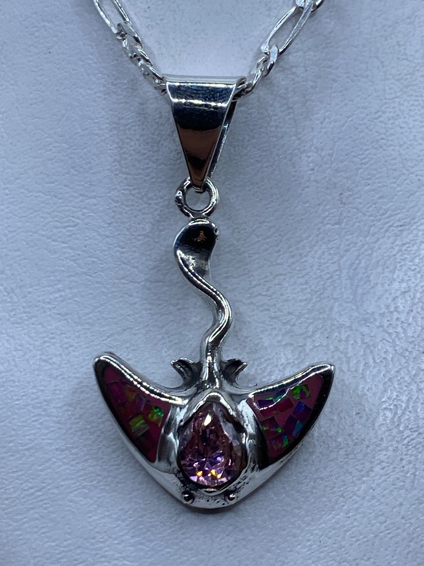 Dije de plata con ópalo de fuego rosa y alas, colgando de cadena plateada