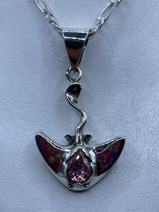 Dije de plata con ópalo de fuego rosa y alas, colgando de cadena plateada