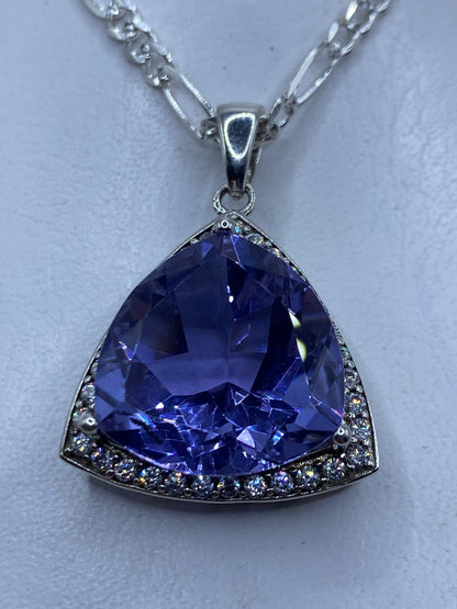 Dije triangular de plata con circonia lavanda colgando de cadena de eslabones