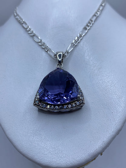 Detalle de la circonia lavanda facetada en el dije triangular