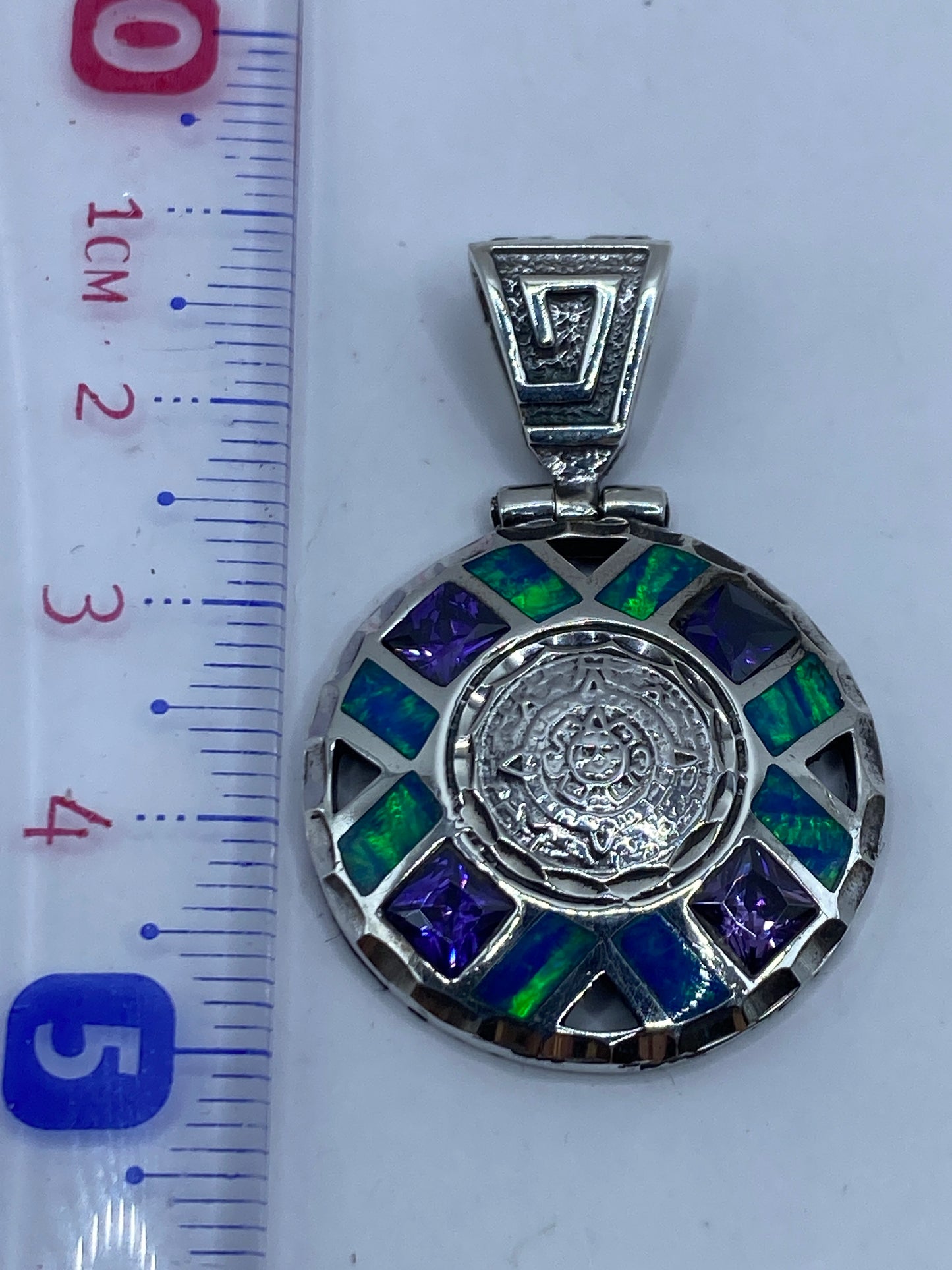 Detalle del reverso del dije con grabado artesanal y acabado de plata pulida
