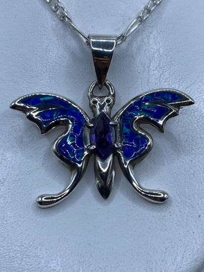 Dije de plata ópalo de fuego azul colgando de cadena plateada contra el pecho