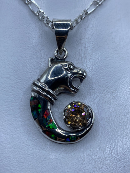 Dije de plata con caballo repujado y ópalo de fuego multicolor colgando de una cadena