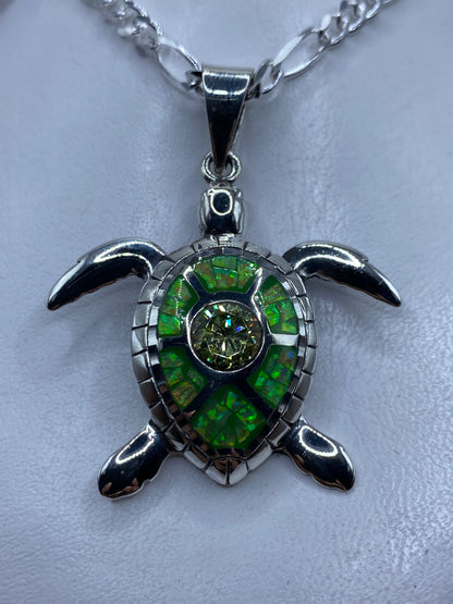 Dije tortuga de plata .950 con ópalo de fuego verde limón, sobre cadena de plata figaro